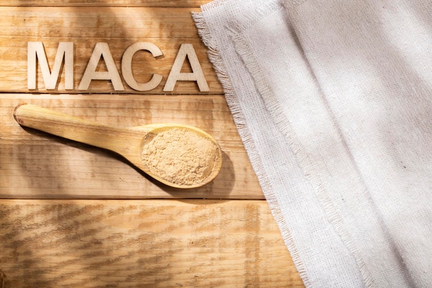 Maca in polvere in ciotola di legno sulla tavola sostanza nutritiva dal Perù