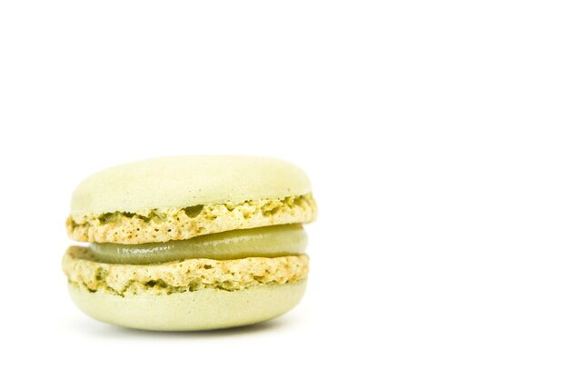 Macaron aromatizzato al pistacchio isolato su un bianco