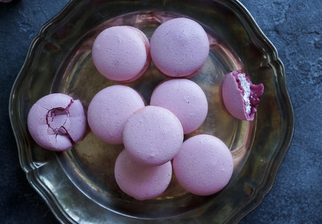 Macarons alla lavanda e mirtilli e caffè cappuccino su tavola di pietra scura con fiori lilla