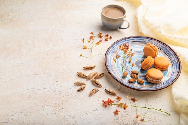 Macarons arancioni o torte di amaretti con una tazza di caffè