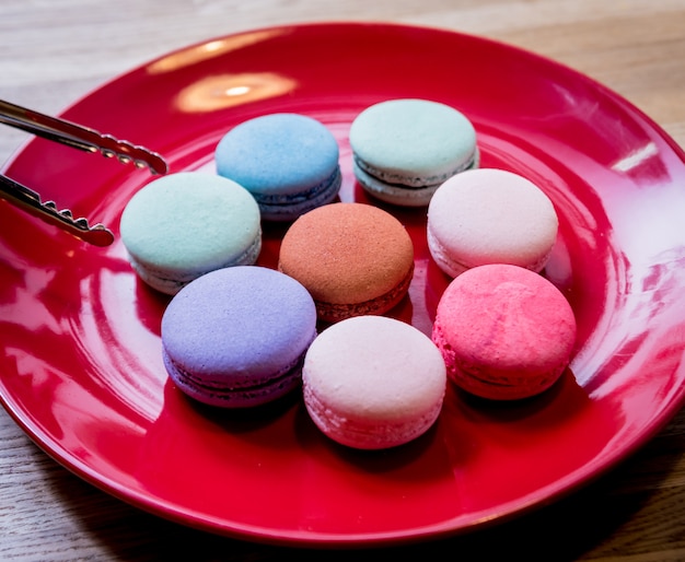 Macarons colorati francesi su un piatto rosso. Ristorante.