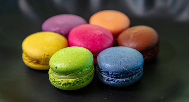 Macarons colorati su sfondo nero vista ravvicinata