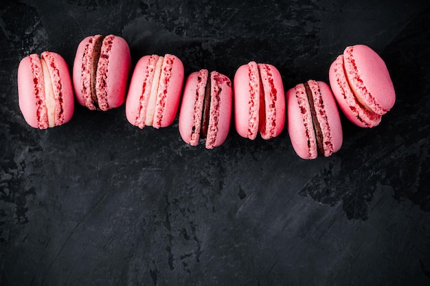 Macarons di torta rosa di San Valentino su sfondo di pietra scura