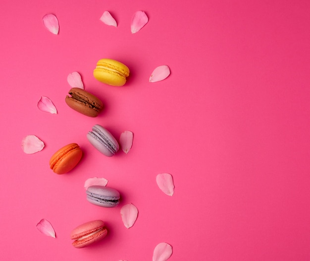 Macarons dolci multicolori con crema e petali di rosa rosa