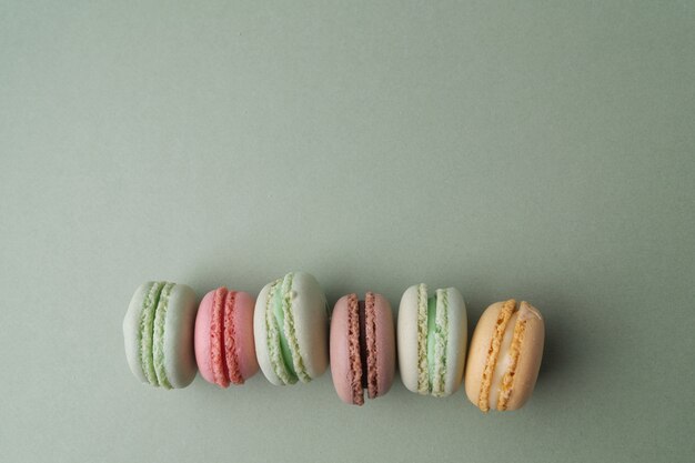 Macarons francesi colorati pastello dell'annata su verde