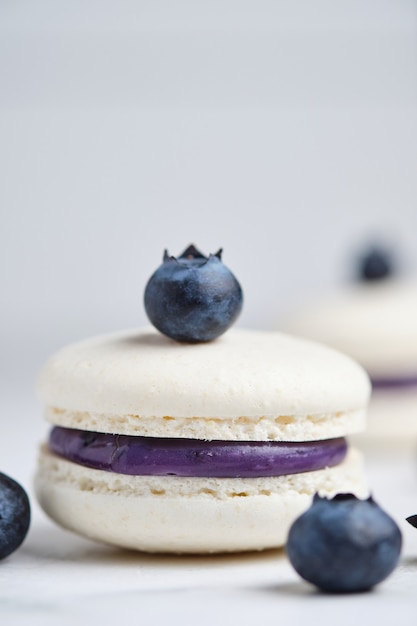 Macarons francesi con ripieno di mirtilli. Delicato dessert con frutti di bosco.