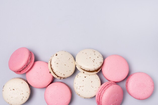 Macarons rosa e bianchi su sfondo blu Dessert francese Macarons al caramello e fragole