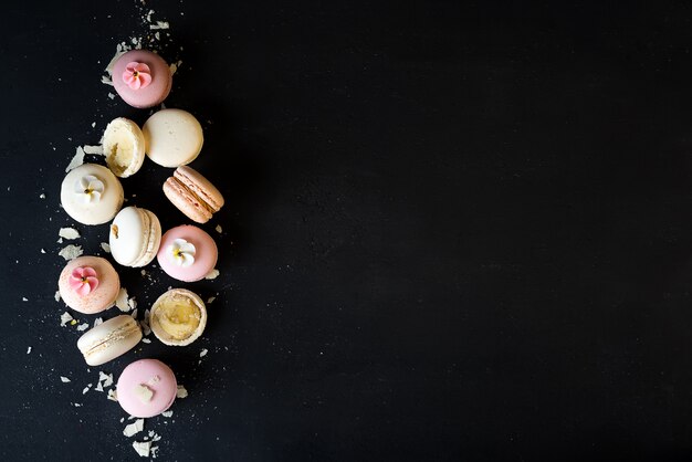 Macarons variopinti su fondo di pietra nero. Vista dall&#39;alto con lo spazio della copia.