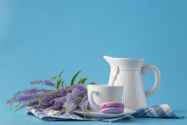 Maccherone di colore pastello con caffè su fondo blu