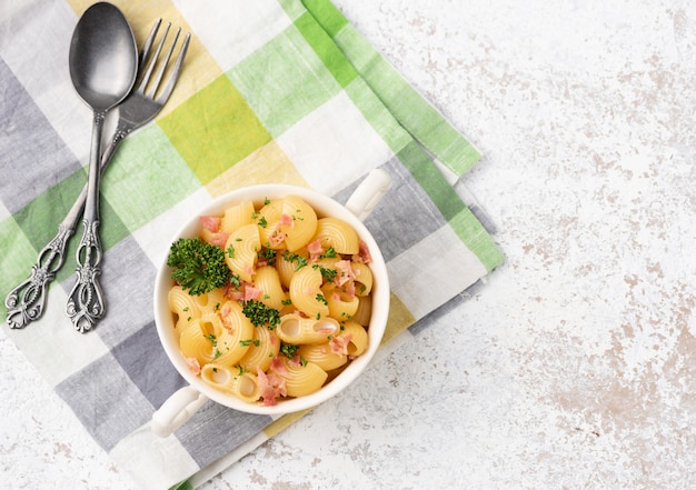 maccheroni con pancetta sulla superficie bianca