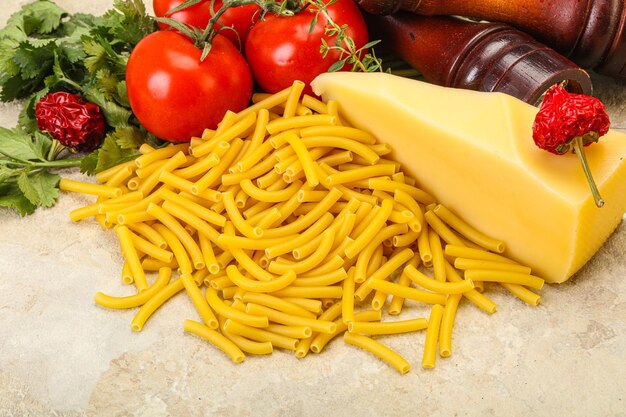 Maccheroni crudi di pasta italiana per cucinare le verdure servite