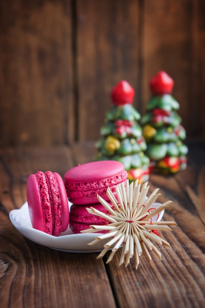 Maccheroni rosa con le decorazioni di natale su fondo di legno