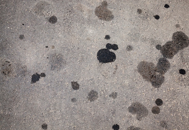 Macchie di olio per auto su una strada asfaltata, macchie di olio motore che fuoriescono dalle auto