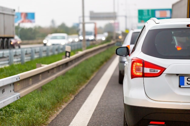 Macchina bianca in attesa nel traffico sull'autostrada nelle ore di punta