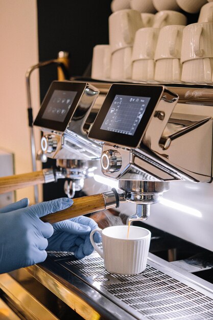 Macchina da caffè professionale con tazza bianca e bibita versata