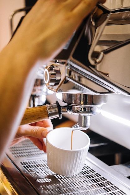 Macchina da caffè professionale con tazza bianca e bibita versata