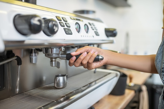 Macchina da caffè, supporto. Mano femminile graziosa che tiene supporto per il filtro della macchina da caffè, il viso non è visibile