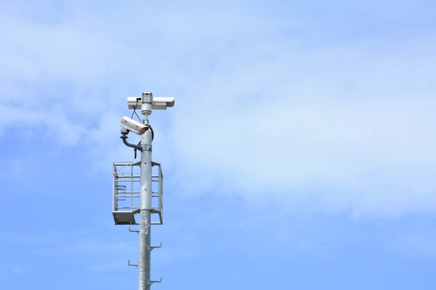 Macchina fotografica del CCTV di sicurezza isolata sulla priorità bassa del cielo blu