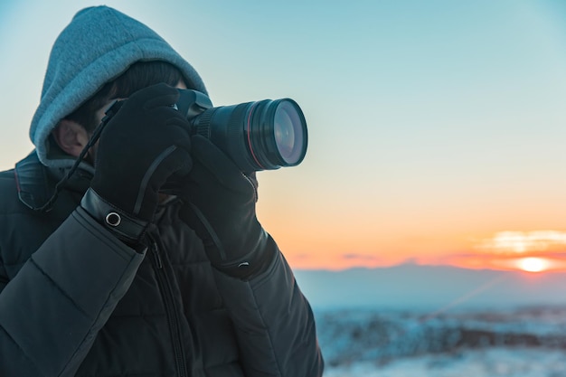 Macchina fotografica della mano dell'uomo in inverno