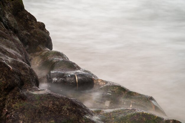 Macchina fotografica di DSLR sulla spiaggia bagnata dall&#39;onda del mare dell&#39;acqua