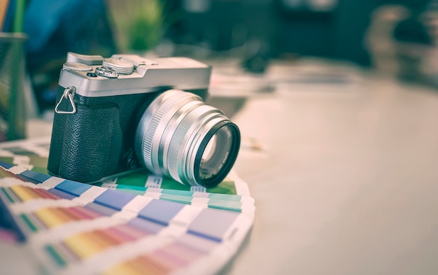 macchina fotografica digitale e campioni di colore su una scrivania