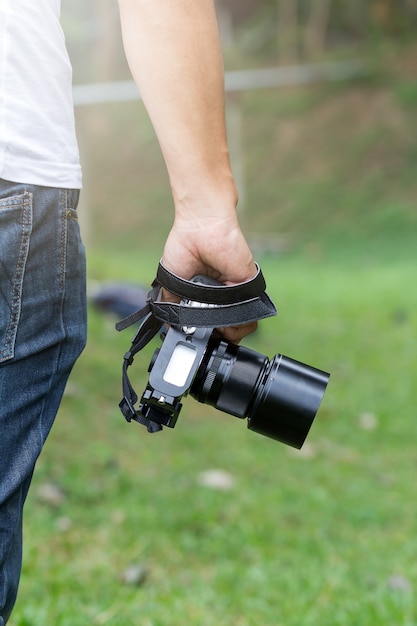 Macchina fotografica in mano, fotografo ai fianchi, vista posteriore