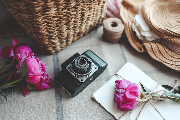 macchina fotografica retrò con libro e fiori di peonia rosa freschi