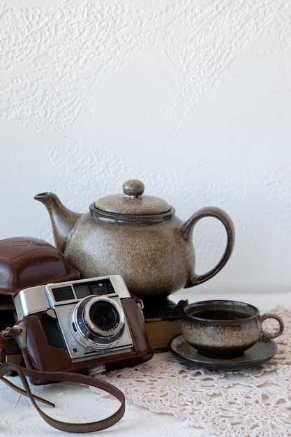 Macchina fotografica vintage e tazza di tè e bollitore