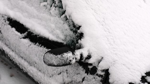 Macchina nera nella neve nel parcheggio.