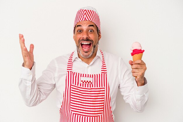 Macchina per il ghiaccio caucasico di mezza età Uomo caucasico che tiene un gelato isolato su sfondo bianco ricevendo una piacevole sorpresa eccitato e alzando le mani