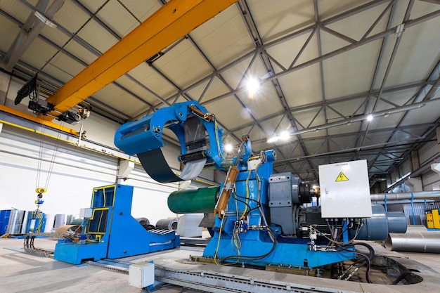 Macchina per la formatura di profili in lamiera, processo di produzione di tegole in acciaio per tetti, produzione industriale. Sfondo di pianta e fabbrica