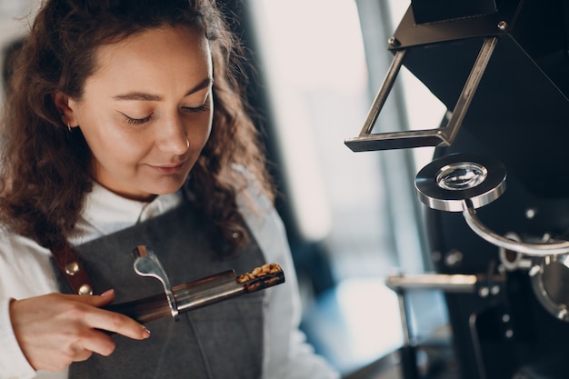 Macchina per la torrefazione del caffè e odore del barista con il tester durante il processo di torrefazione del caffè,