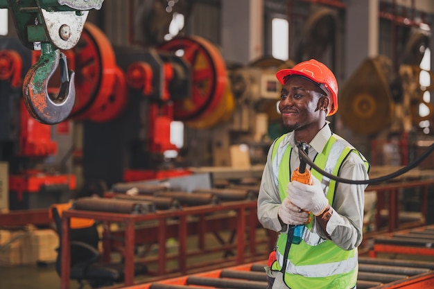 Macchina pesante di controllo del lavoratore afroamericano nella fabbrica