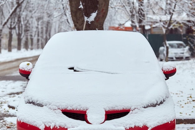 Macchina rossa parcheggiata sulla strada nella giornata invernale, vista posteriore. Mock-up per adesivo o decalcomanie