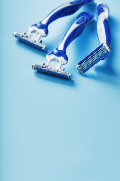 Macchine da barba blu in fila su sfondo blu