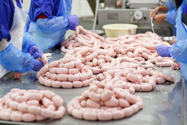 Macellai che trasformano le salsiccie alla fabbrica della carne.