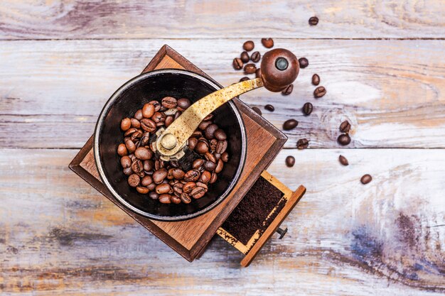 Macinacaffè d'annata con i fagioli sulla tavola di legno