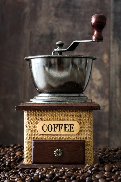 Macinacaffè e chicchi di caffè su fondo di legno rustico