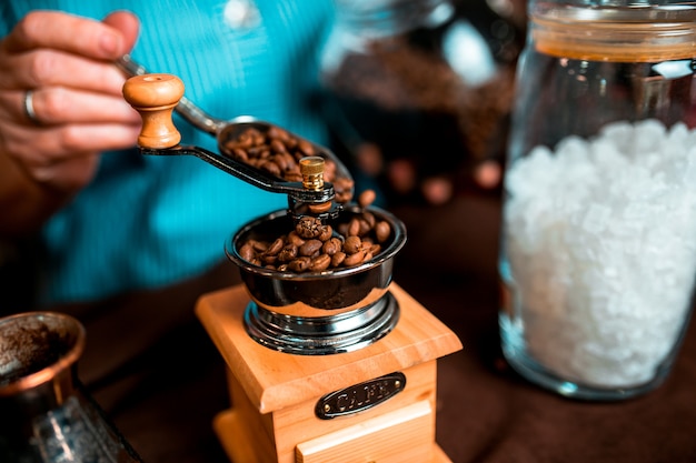 Macinacaffè manuale in legno con chicchi di caffè all&#39;interno.