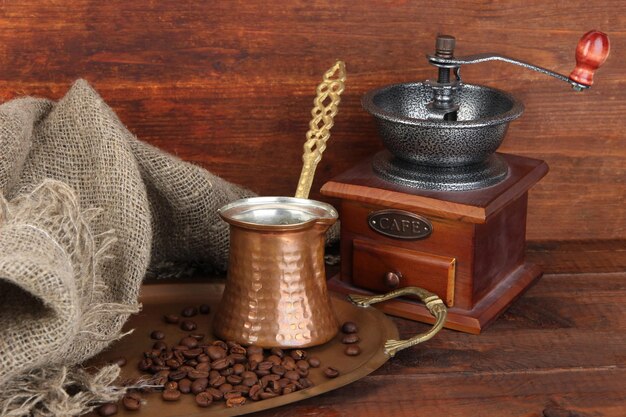 Macinacaffè turco e chicchi di caffè sul vassoio dorato su fondo di legno