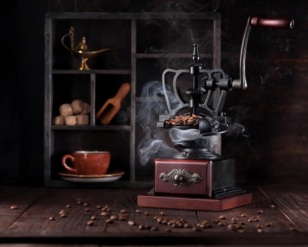 Macinacaffè vintage di natura morta e chicchi di caffè