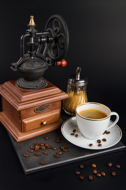 Macinino in legno con tazza di caffè