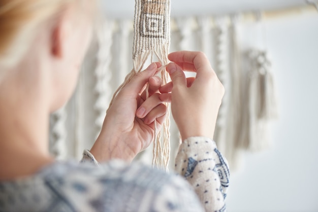 Macrame, l'hobby delle donne. Le mani si chiudono. Tessuto a maglia