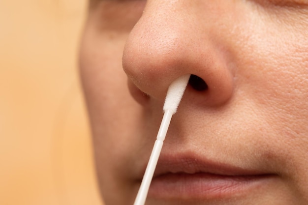 Macro del naso di una donna sospettata di COVID19 che esegue un test di diagnosi rapida