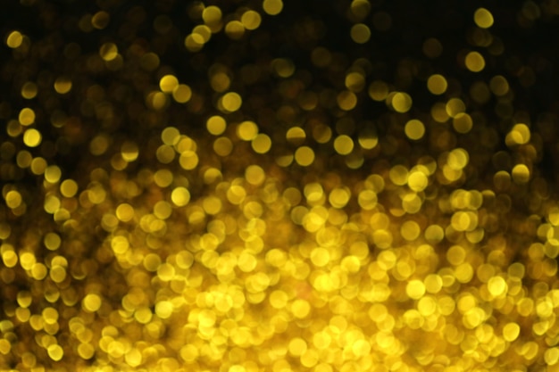 Macro glitter oro con brillante bokeh su sfondo nero. Texture splendente.