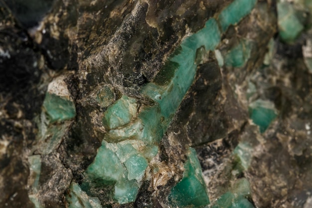 Macro minerale di pietra verde smeraldo in roccia su sfondo bianco