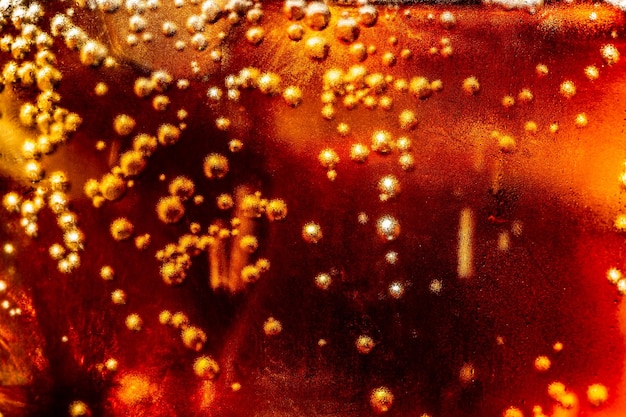 macro soft drink texture Vetro per bibite analcoliche con schizzi di ghiaccio su sfondo scuro Vetro cola in celebrat