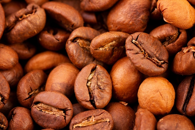 Macrofotografia di chicchi di caffè, la trama di chicchi di caffè. Chicchi di caffè tostati su uno sfondo scuro