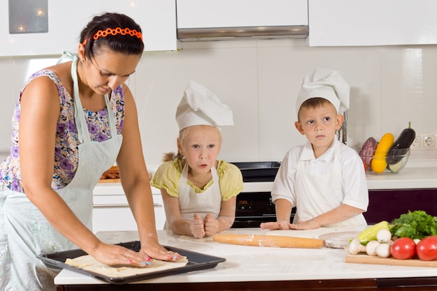 Madre aiuta lo chef Bambini a preparare il cibo in cucina