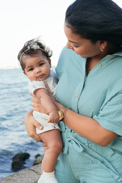 Madre all'aperto mentre tiene in braccio il suo bambino e mostra affetto